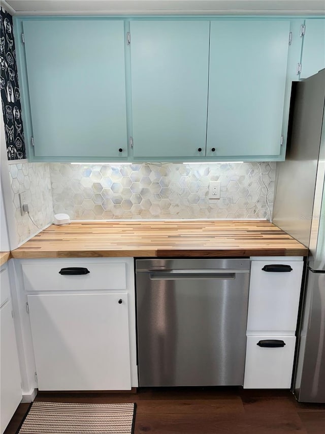 kitchen with blue cabinets, backsplash, and stainless steel refrigerator