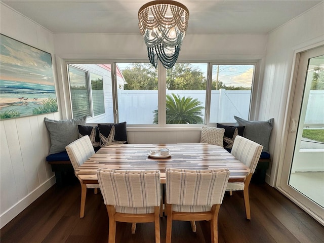 dining space with a healthy amount of sunlight, a notable chandelier, and dark hardwood / wood-style flooring