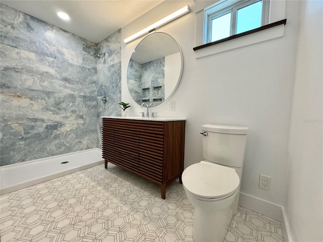 bathroom with tiled shower, vanity, and toilet