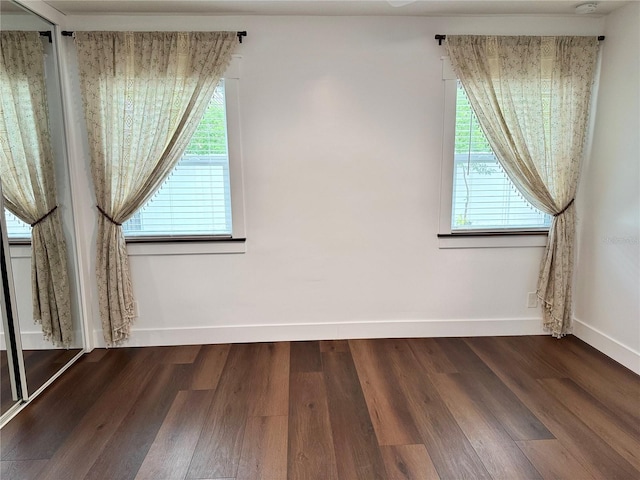 additional living space featuring plenty of natural light and dark hardwood / wood-style floors