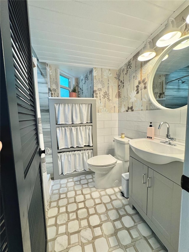 bathroom with vanity, toilet, tile walls, and decorative backsplash