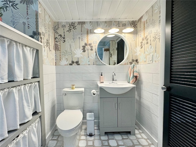 bathroom with tile walls, backsplash, toilet, and vanity