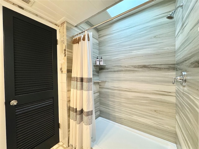 bathroom featuring a shower with curtain and a skylight