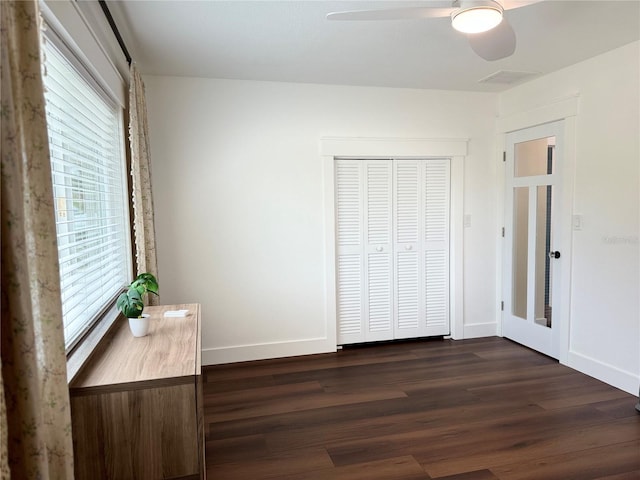 unfurnished bedroom with dark wood-type flooring, ceiling fan, and a closet