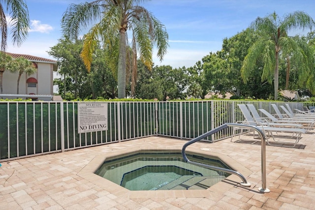 view of swimming pool featuring a patio area and a hot tub