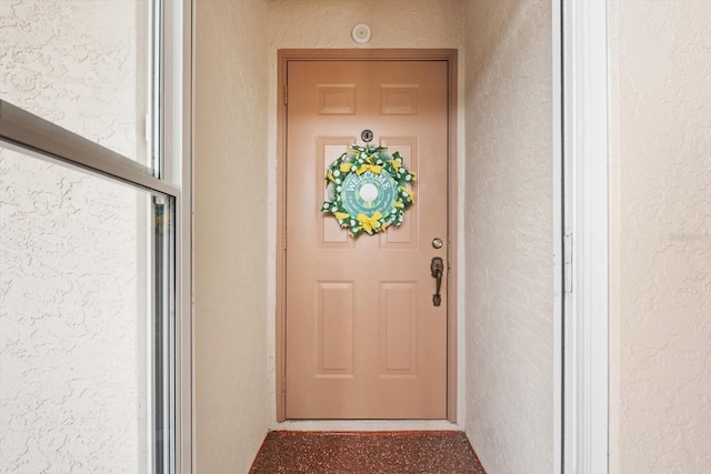 doorway to property featuring stucco siding