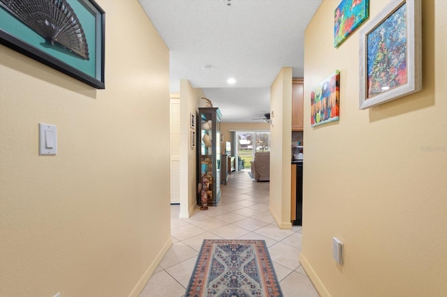 hallway featuring light tile patterned floors and baseboards