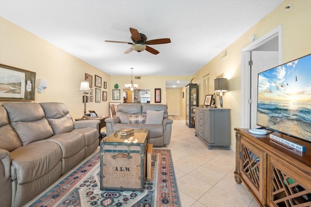 living room with light tile patterned floors, visible vents, and ceiling fan with notable chandelier