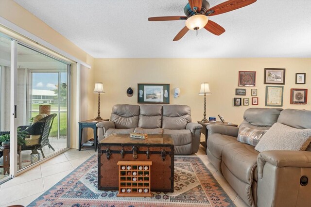 tiled living room with ceiling fan and a textured ceiling