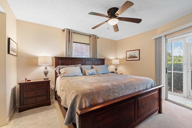 bedroom featuring a textured ceiling, access to exterior, ceiling fan, and multiple windows