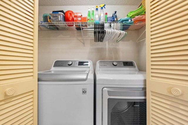 laundry room with washer and dryer and a textured ceiling