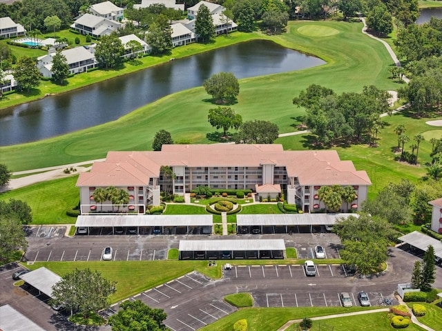 aerial view with golf course view and a water view