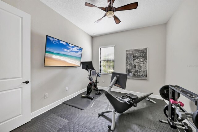 workout room with a textured ceiling and ceiling fan