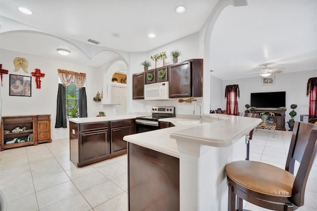 kitchen with ceiling fan, electric range, sink, kitchen peninsula, and light tile patterned flooring