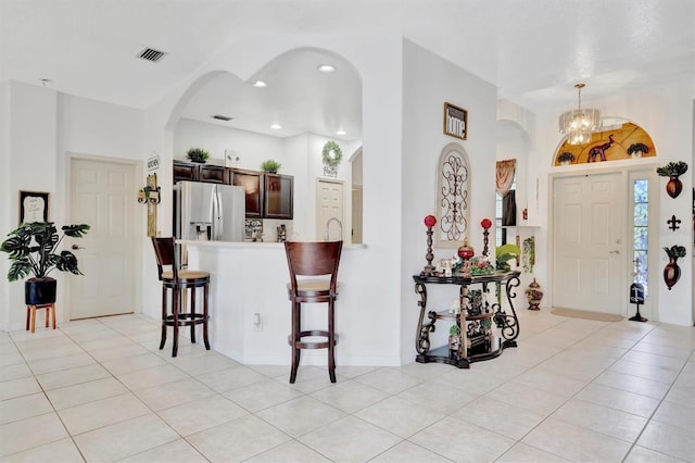 tiled entrance foyer with a chandelier