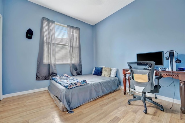 bedroom with light hardwood / wood-style flooring and lofted ceiling