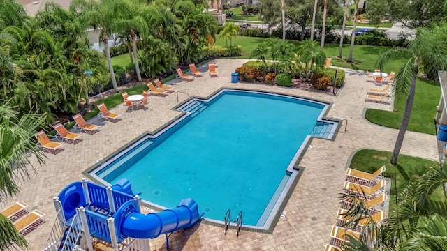 view of pool with a lawn, a patio, and a water slide