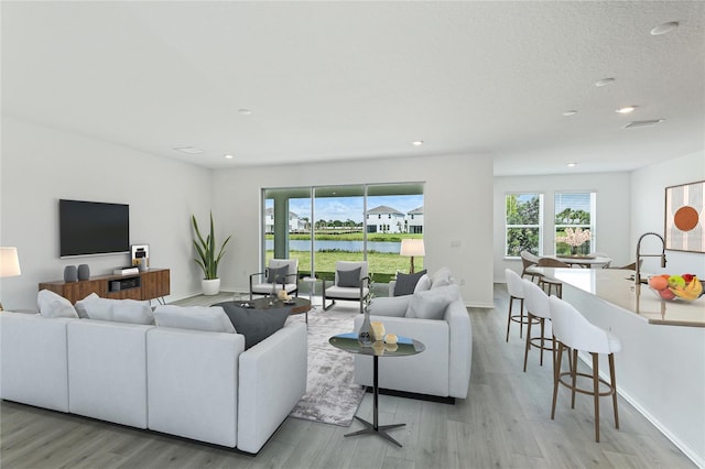 living area featuring recessed lighting, light wood-style flooring, and baseboards