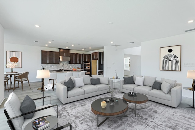 living area featuring visible vents and recessed lighting