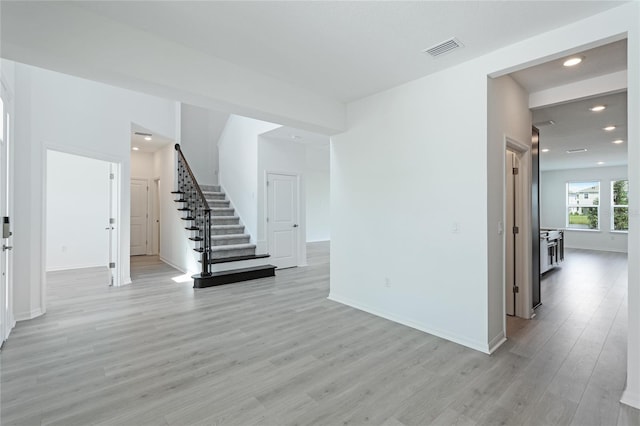 interior space with recessed lighting, visible vents, light wood-style floors, baseboards, and stairs