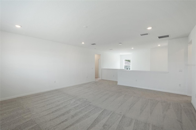 spare room featuring light carpet, visible vents, and recessed lighting