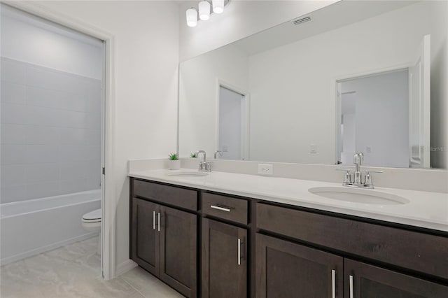 bathroom featuring toilet, double vanity, visible vents, and a sink