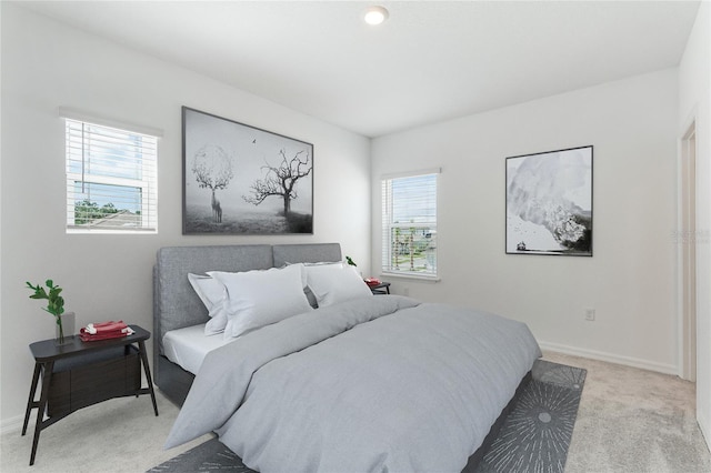 bedroom featuring light carpet and baseboards