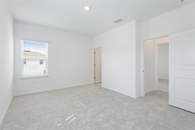 unfurnished bedroom with baseboards, visible vents, and light colored carpet