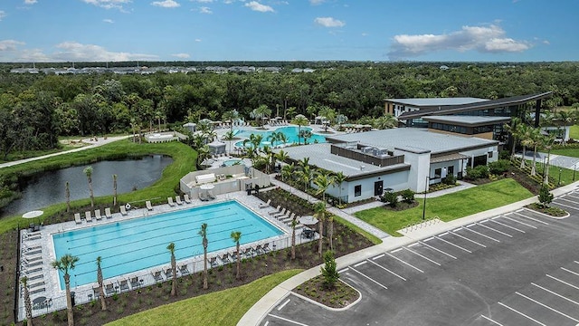 birds eye view of property with a water view and a wooded view