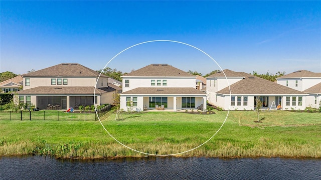 rear view of house with a patio area, a yard, a water view, and fence private yard