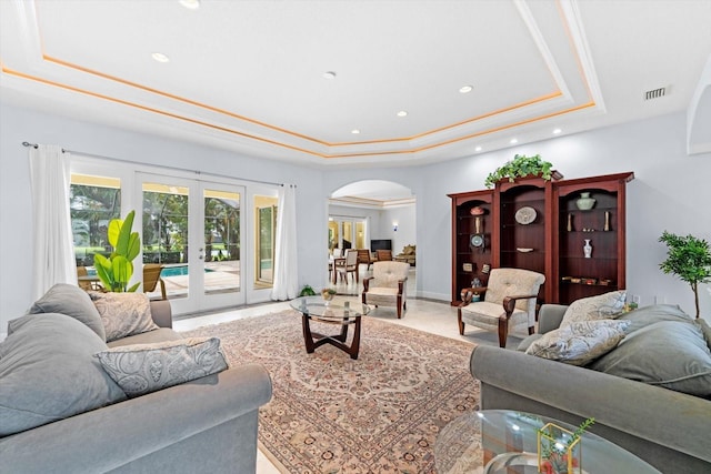 living room with french doors and a tray ceiling