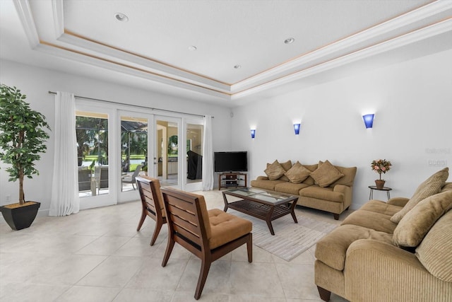 living room featuring light tile patterned flooring, ornamental molding, a tray ceiling, and french doors