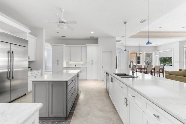 kitchen with gray cabinetry, stainless steel appliances, sink, pendant lighting, and white cabinetry