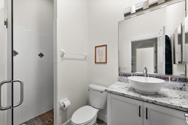 bathroom with vanity, toilet, and a shower with shower door