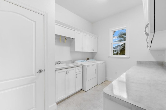 clothes washing area with cabinets, light tile patterned flooring, washer and dryer, and sink