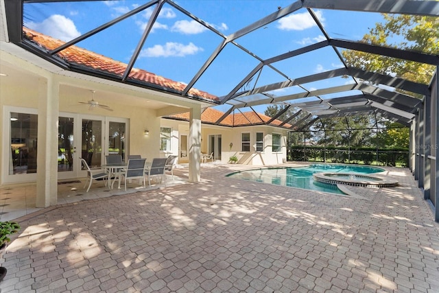 view of pool with glass enclosure, an in ground hot tub, a patio area, and ceiling fan