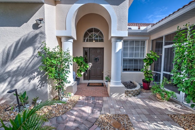 property entrance with a tiled roof and stucco siding