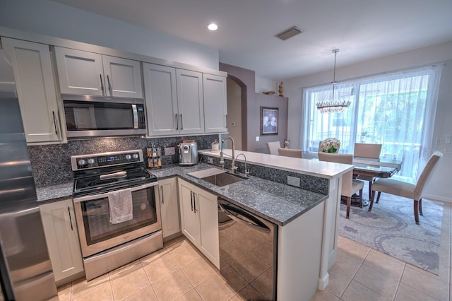 kitchen with light tile patterned floors, visible vents, appliances with stainless steel finishes, a sink, and a peninsula