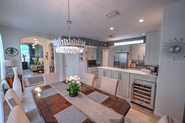 dining area with light tile patterned floors, arched walkways, recessed lighting, beverage cooler, and visible vents