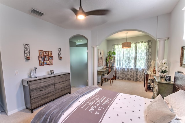 bedroom with ceiling fan, arched walkways, light carpet, visible vents, and decorative columns