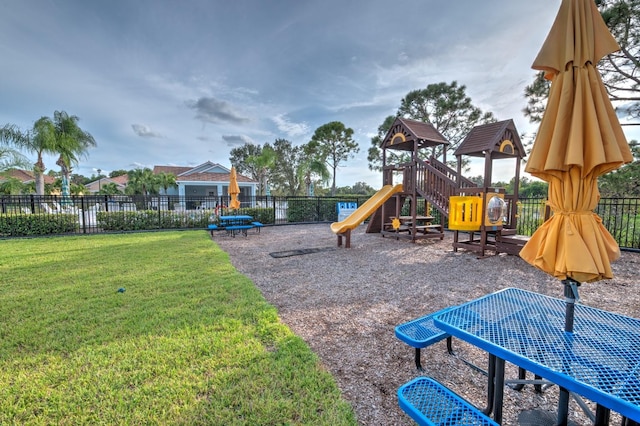 community jungle gym featuring fence and a lawn