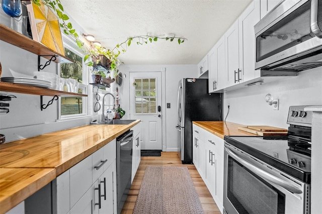 kitchen with plenty of natural light, butcher block counters, and stainless steel appliances