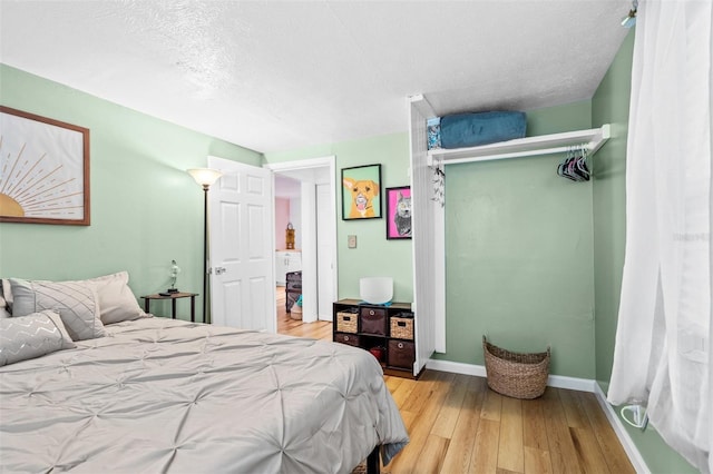 bedroom with light wood-type flooring and a textured ceiling