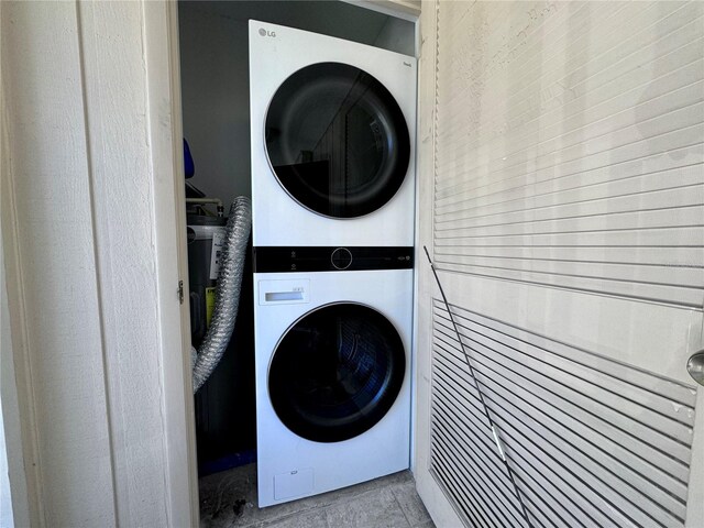 washroom featuring light tile patterned floors and stacked washer / dryer