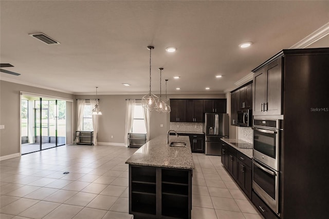 kitchen featuring sink, light tile patterned floors, ornamental molding, an island with sink, and stainless steel appliances