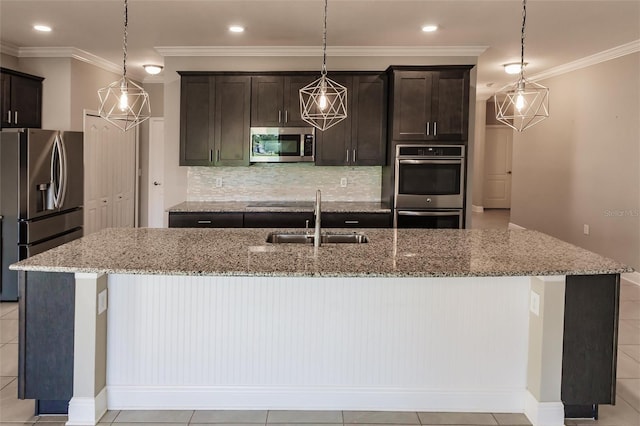 kitchen with hanging light fixtures, an island with sink, and appliances with stainless steel finishes