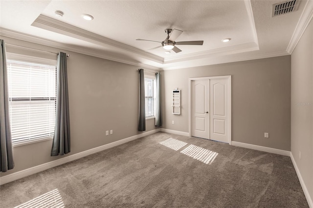 carpeted empty room with crown molding, a tray ceiling, a textured ceiling, and ceiling fan