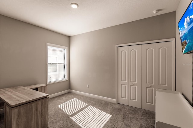 unfurnished bedroom with dark carpet and a closet