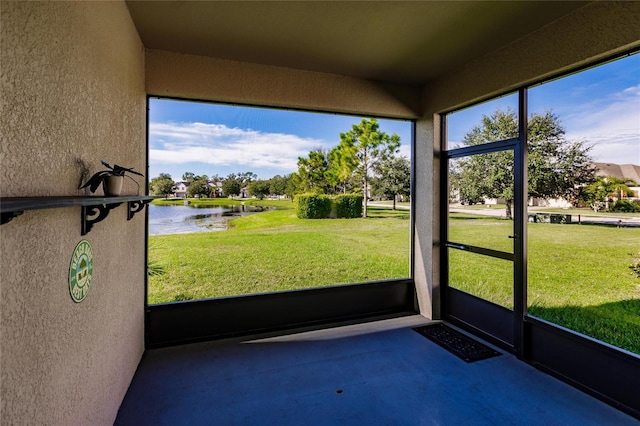 unfurnished sunroom featuring a water view