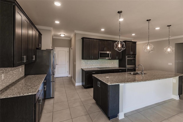 kitchen featuring stainless steel appliances, an island with sink, sink, and pendant lighting